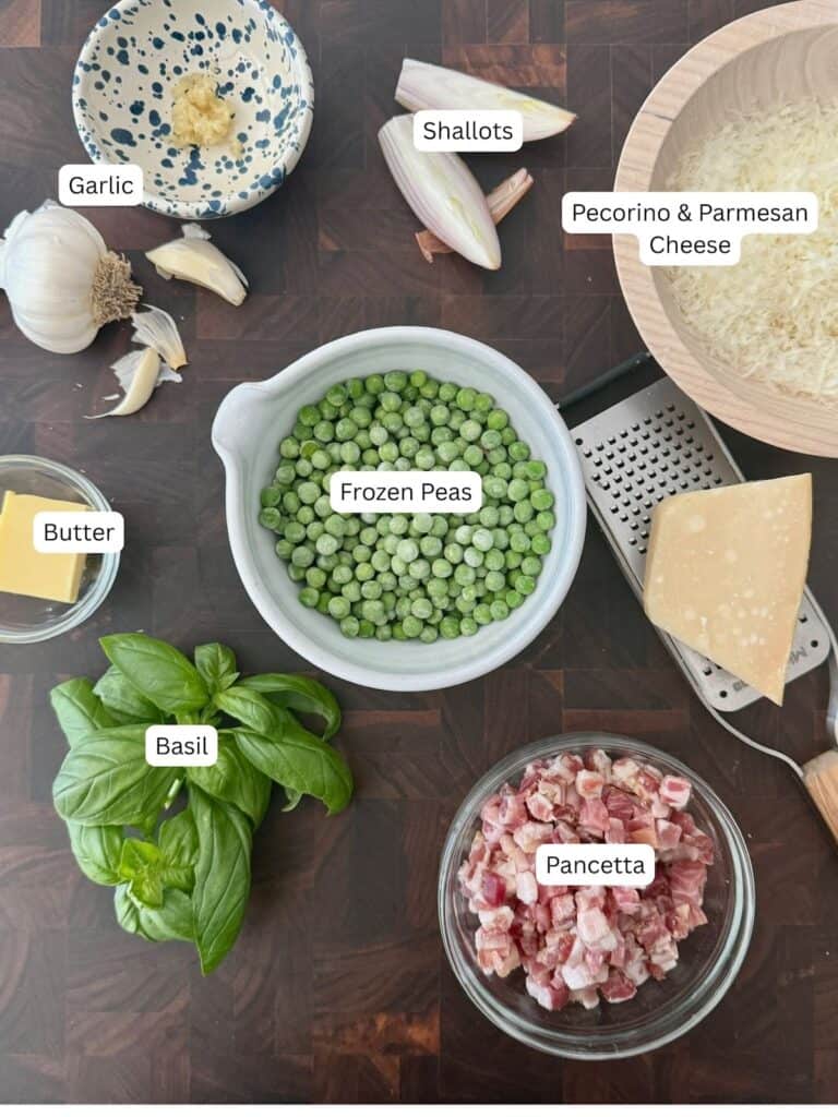 Photo of ingredients for the pasta piselli in glass bowls displayed on a wooden cutting board.
